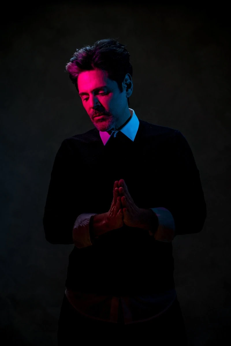 salon owner poses for headshot with pink and blue light